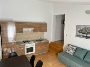 a kitchen and living room with a couch and a table at Apartman Polegubic in Biograd na Moru