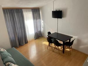 een woonkamer met een zwarte tafel en stoelen bij Apartman Polegubic in Biograd na Moru