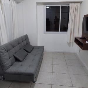 uma sala de estar com um sofá e uma janela em Beira Mar Praia Jatiúca em Maceió