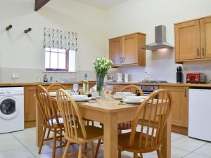 a kitchen with a wooden dining table and chairs at Kingfisher - Uk42520 in Aldwincle Saint Peter