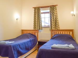two beds in a room with a window at Kingfisher - Uk42520 in Aldwincle Saint Peter