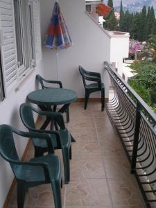 eine Terrasse mit 3 Stühlen und einem Tisch auf dem Balkon in der Unterkunft Apartments Duce-Golubinka (239) in Duće