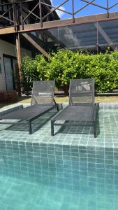 2 sillas sentadas junto a una piscina en Villa 56, en São Miguel do Gostoso