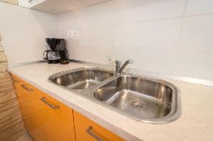 a kitchen with a stainless steel sink on a counter at Guesthouse Lopar (4421) in Lopar