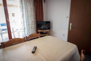 a remote control on a bed in a room with a television at Beachfront Apartments Lopar (4419) in Lopar
