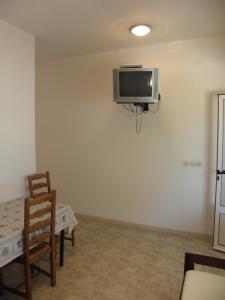 Pokój ze stołem i krzesłami oraz telewizorem na ścianie w obiekcie House Lumbarda (876) w mieście Lumbarda