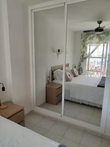 1 dormitorio con cama y espejo grande en Best apartment ever in El Faro de Mijas en Mijas Costa