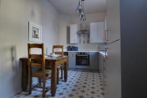 a kitchen with a table and chairs and a refrigerator at Lovely Hudds home, x4 double bedrooms & parking in Huddersfield