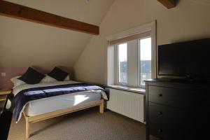 a bedroom with a bed and a window and a dresser at Lovely 4 Bed House in Huddersfield with parking in Huddersfield