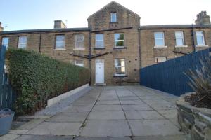 an old brick house with a fence and a driveway at Lovely 4 Bed House in Huddersfield with parking in Huddersfield