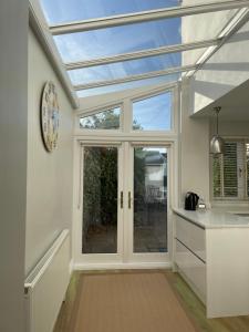 a kitchen with a conservatory with a glass roof at Wren House in Sidmouth