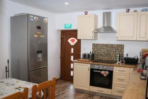 a kitchen with a stainless steel refrigerator and a table at Casa de oaspeti Kinga's Crown in Băile Tuşnad