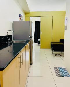 a kitchen with a sink and a refrigerator at Wind Suites Tagaytay at SMDC in Tagaytay