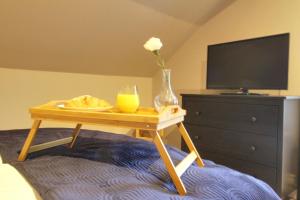 a table with a vase of flowers and a glass of orange juice on at Lovely 4 Bed House in Huddersfield with parking in Huddersfield