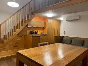 a living room with a wooden table and a staircase at Palava eu 7 in Pavlov