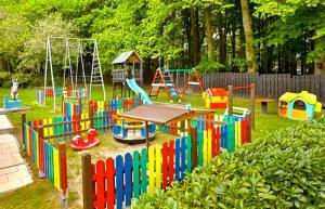 a playground with a colorful fence and play equipment at Hotel Busch-Atter in Osnabrück