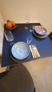 a blue table with plates and utensils on it at Apartment_BaLi in Linkenheim-Hochstetten