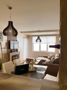 un salon avec un canapé et une table avec un ordinateur portable dans l'établissement Borski Luxury Apartments, à Zlatibor