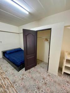 ein Schlafzimmer mit einem blauen Bett in einem Zimmer in der Unterkunft Ratanawong Place 801 in Bangkok