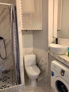 a bathroom with a toilet and a sink and a washing machine at Comfort Home Soborna 283 in Rivne