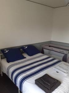 a bed with blue and white sheets and blue pillows at super logement en plein cœur de la ville , Chez Tify in Brienne-le-Château