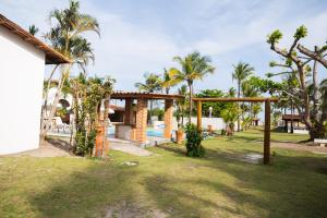 a resort with a pool and palm trees at Pousada Freitas Alonso in Nova Viçosa