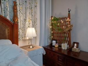 ein Schlafzimmer mit einem Bett und einem Tisch mit einer Lampe in der Unterkunft Grandmother's Vegetable garden in Anseong