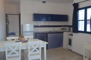 Palmeira的住宿－LA VELA，厨房配有白色的桌椅