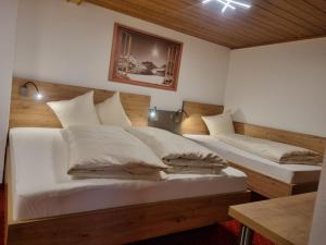 een slaapkamer met twee bedden met witte lakens en kussens bij Haus Wildbach in Kappl