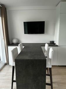 une salle à manger avec une table noire et des chaises blanches dans l'établissement Apartment Torremolinos, à Torremolinos