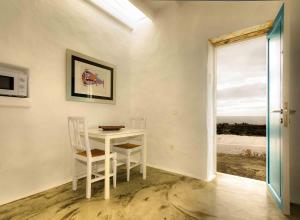 ein Esszimmer mit einem Tisch, Stühlen und einem Fenster in der Unterkunft La Casa de las Salinas in Punta de Mujeres