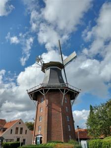 un moulin à vent au-dessus d'un bâtiment en briques dans l'établissement Stadthaus mit Dachterrasse, à Varel