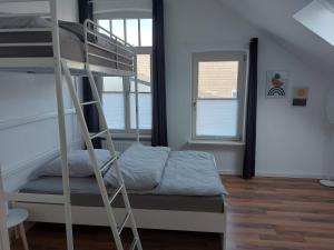 - une chambre avec des lits superposés et une échelle dans l'établissement Stadthaus mit Dachterrasse, à Varel