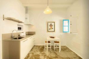 a kitchen with a sink and a table with chairs at La Casa de las Salinas in Punta Mujeres