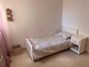 een kleine slaapkamer met een bed en een nachtkastje bij Love House Tanger in Tanger