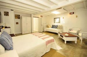 プンタ・ムヘーレスにあるLa Casa de las Salinasのベッドルーム1室(ベッド1台、ソファ、テーブル付)