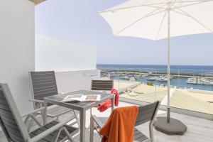 - un balcon avec une table, des chaises et un parasol dans l'établissement Casa Mercedes, Puerto del Carmen, à Puerto del Carmen