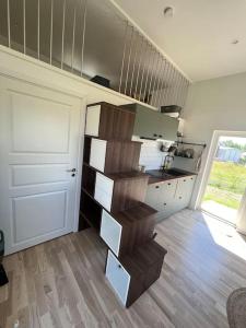 a kitchen with a staircase in the middle of a room at Your own 30sqm house with kitchen, sauna and loft. in Malmö
