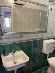 y baño con lavabo, aseo y espejo. en Španić palace, en Korčula