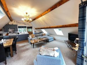 a living room with a blue couch and a kitchen at Cosy Alpine Cottage in the heart of Lancashire in Catterall