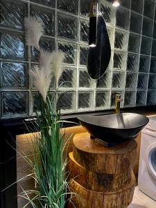 a bathroom with a black bowl sink on a wooden stump at Pod Lwem in Kościerzyna