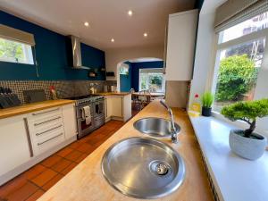 a kitchen with a large metal sink in the middle at Stylish 4 bed house with parking in central Norwich in Norwich