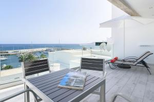 a table and chairs on a balcony with a view of the ocean at Casa Mercedes, Puerto del Carmen in Puerto del Carmen