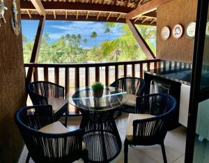 a table and chairs on a balcony with a view of the ocean at Cupe Beach Living Flat in Ipojuca