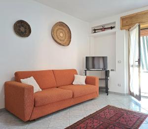 uma sala de estar com um sofá laranja e uma televisão em Costa vacanze in low cost - IUN P2923 em Villaputzu