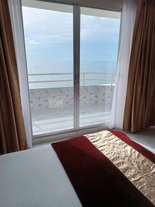 una camera da letto con una grande finestra con vista sull'oceano di Seaview Studio with beach access Hua Hin KhaoTao a Ban Bo Kaeo