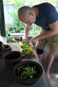 Un uomo che prepara il cibo su un bancone di The Misty Mountain Guest House a Haldummulla