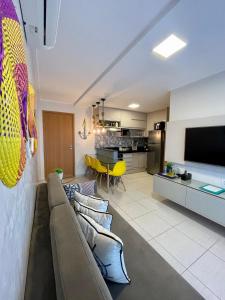 a living room with a couch and a tv and a kitchen at Cupe Beach Living Flat in Ipojuca