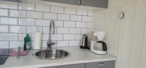 a kitchen counter with a sink and a mixer at Cute little cottage in Höllviken in Höllviken