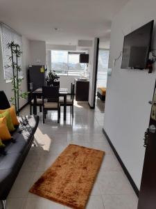 a living room with a couch and a dining room at Apartamentos a 3 minutos del Parque del Café in Armenia